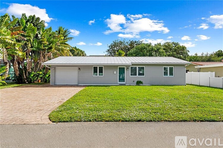 A house with a green lawn and a driveway in front of it.