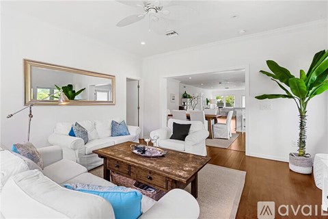A living room with white furniture and a wooden coffee table.