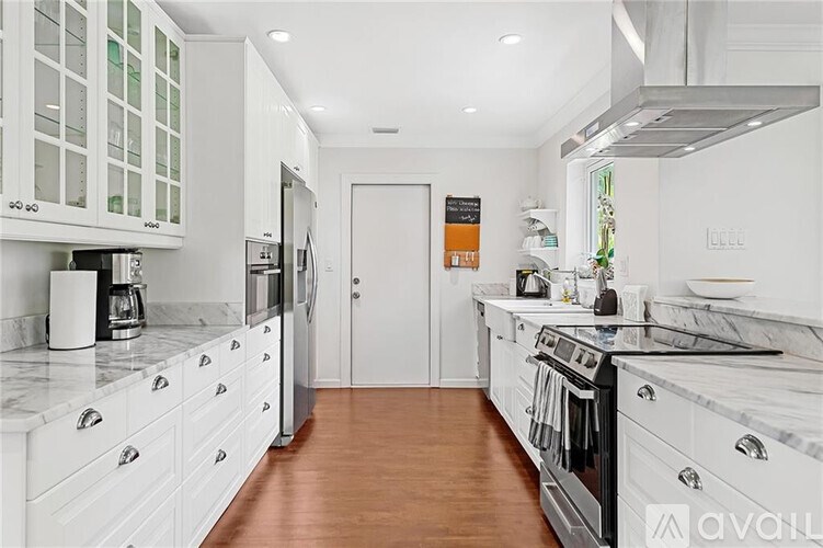A kitchen with white cabinets and a black stove top oven.