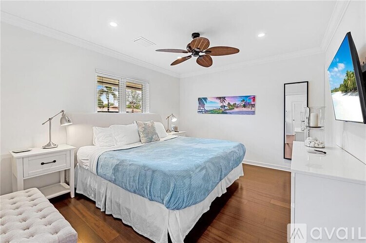 A bedroom with a bed, nightstand, and a ceiling fan.