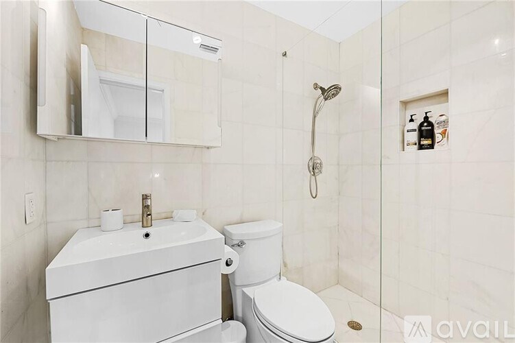 A white toilet and sink in a bathroom.