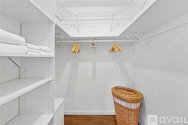 A white laundry room with a basket on the floor.