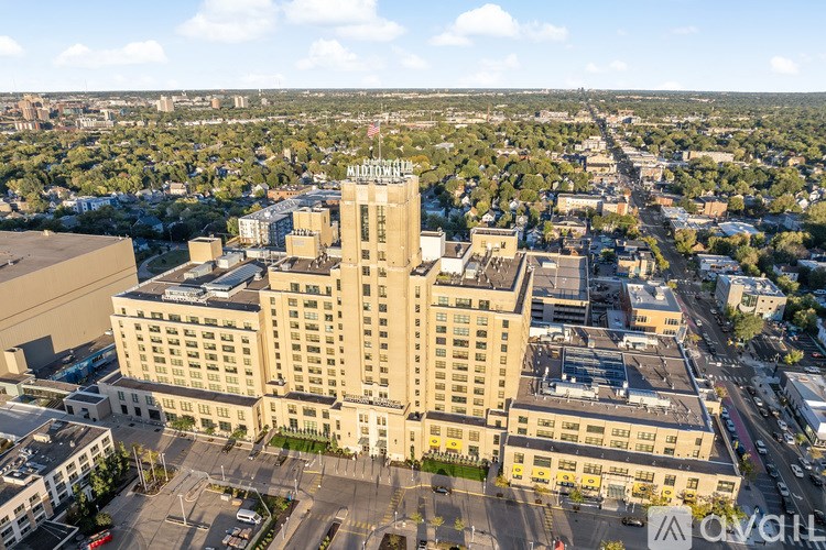 An aerial view of a city with a large building in the center that has a sign on top that reads "Motel".