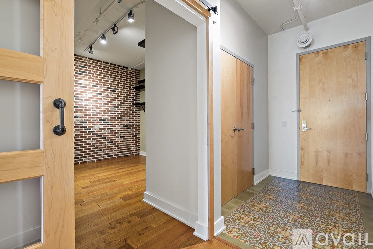 A room with a brick wall and wooden floors.