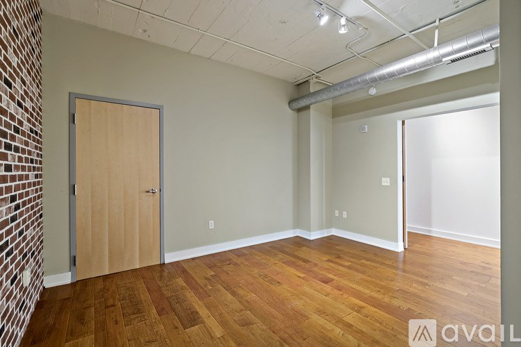 A room with wooden floors and a brick wall.