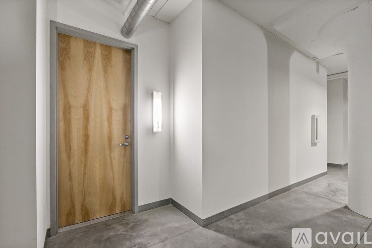A room with a wooden door and a wall-mounted light fixture.