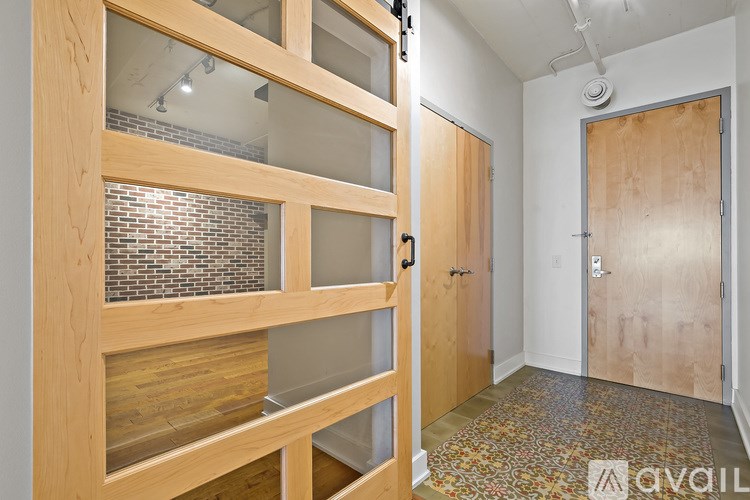 A hallway with a brick wall and wooden doors.