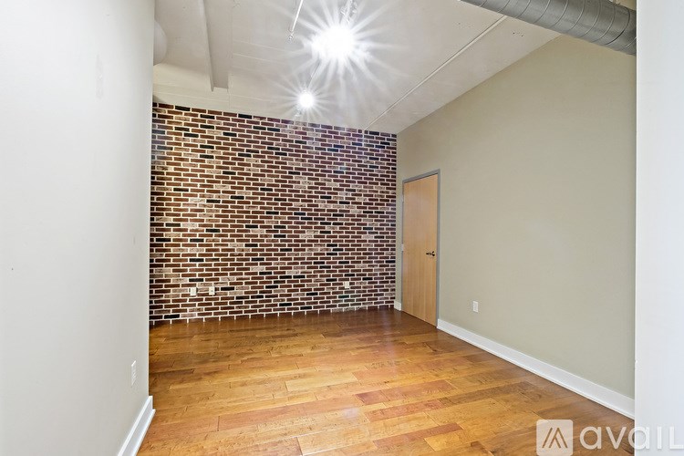 A room with a brick wall and wooden flooring.