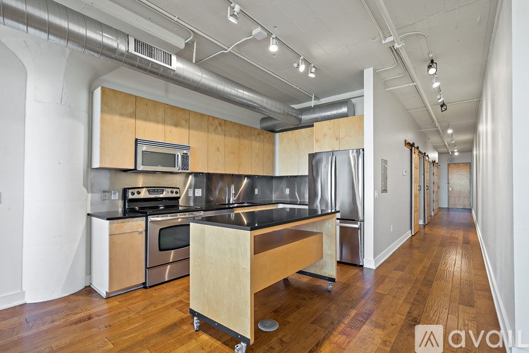 A kitchen with wooden floors and stainless steel appliances.