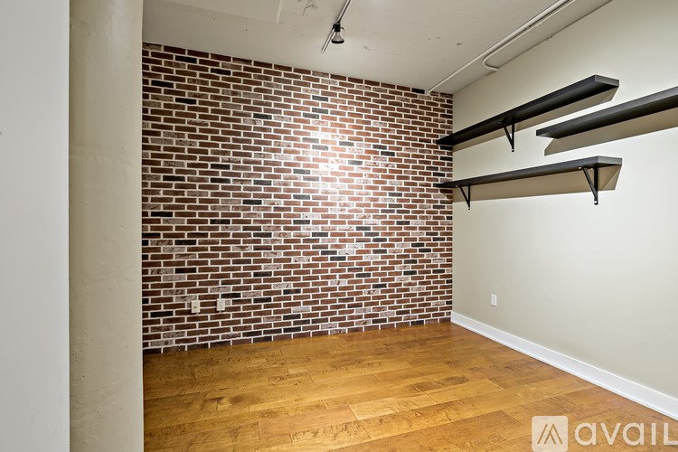 A room with a brick wall and wooden flooring.
