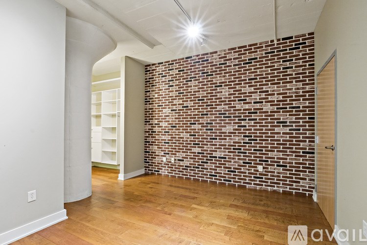 A room with a brick wall and wooden flooring.