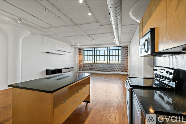 A kitchen with wooden cabinets and black countertops.