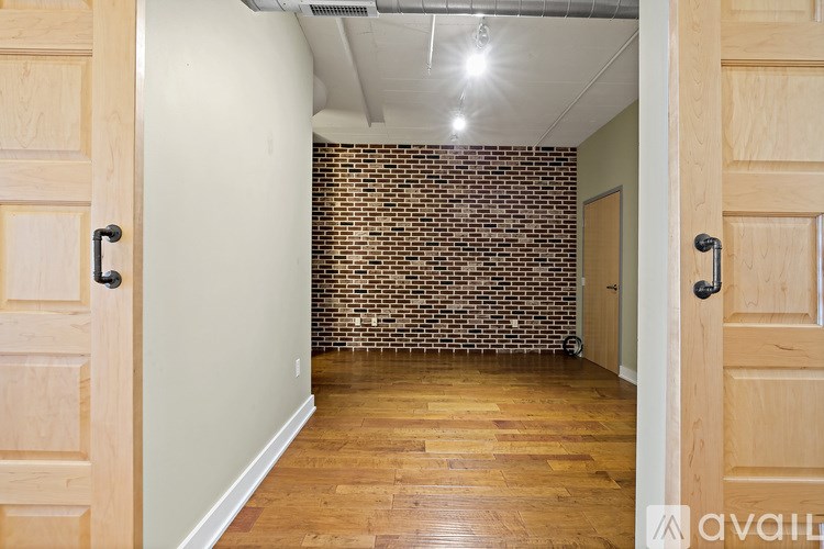 A room with wooden floors and a brick wall.