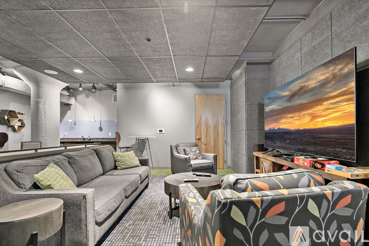 A living room with a grey couch, a green couch, a coffee table, and a TV on a stand.