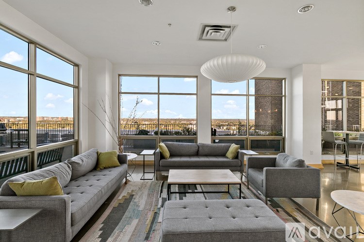 A living room with a grey sofa and a large window.