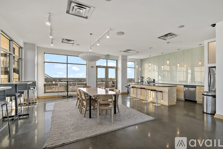 A modern kitchen and dining area with a large window overlooking the city.