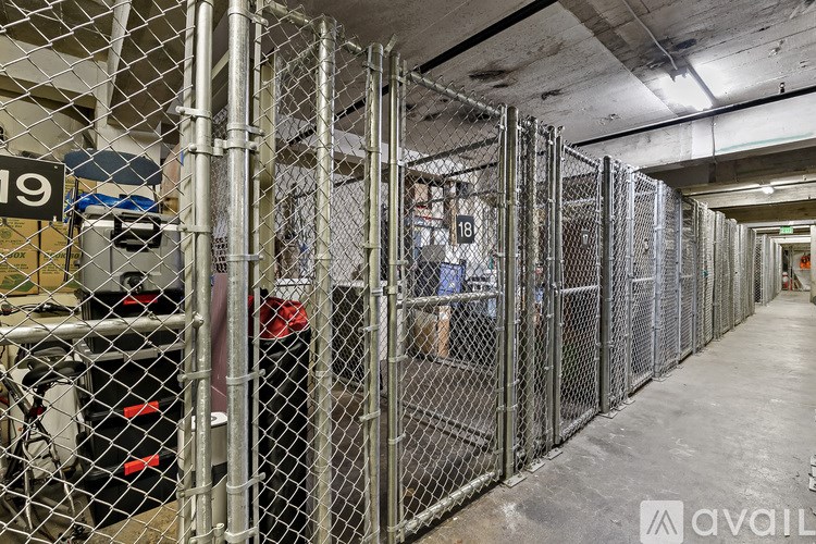 A long hallway with a chain link fence on the left side.