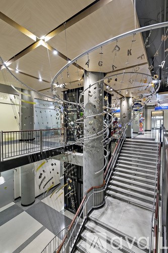 A large metal staircase with a metal railing and a metal pole with letters on it.