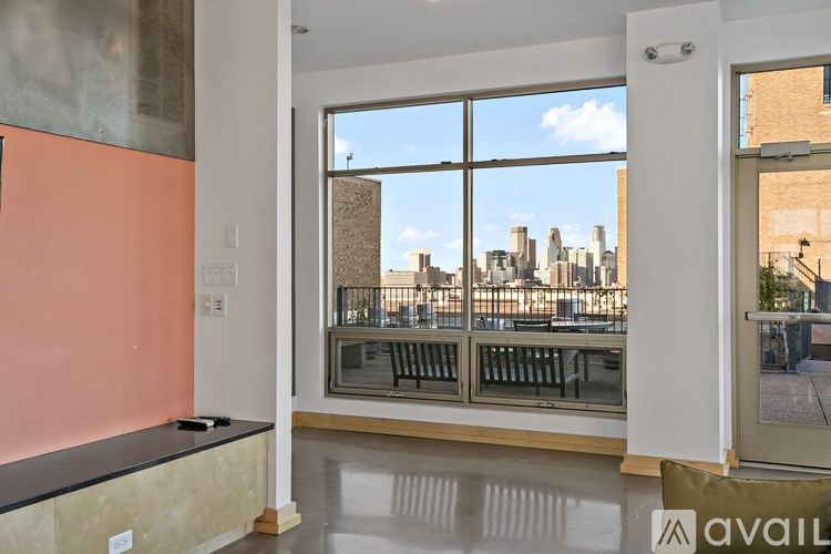A room with a large window overlooking a city skyline.