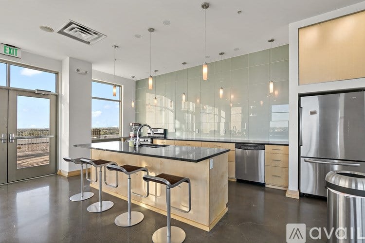 A modern kitchen with a bar area and a view of the outdoors.