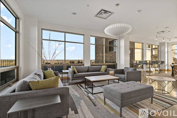 A living room with a grey couch and a grey ottoman.