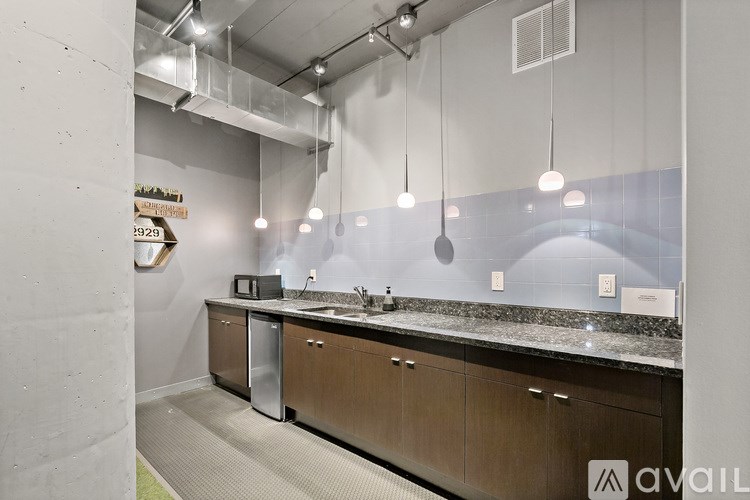 A modern kitchen with a marble countertop and wooden cabinets.