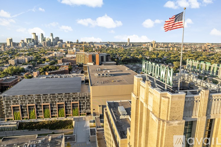 A view of a cityscape with a large building in the foreground and a flag flying in the background.