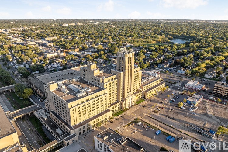 A cityscape with a large building in the center and a parking lot in the foreground.