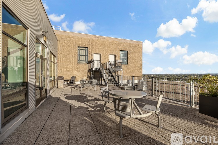 A patio area with a table and chairs overlooking a cityscape.