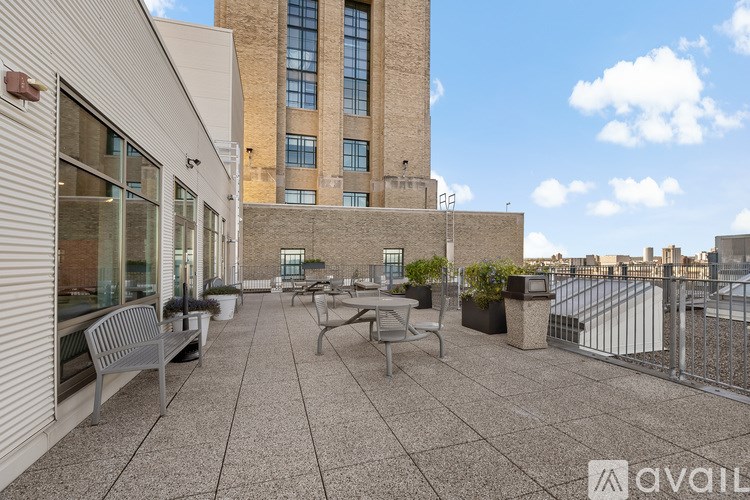 A patio area with a table and chairs is surrounded by buildings.