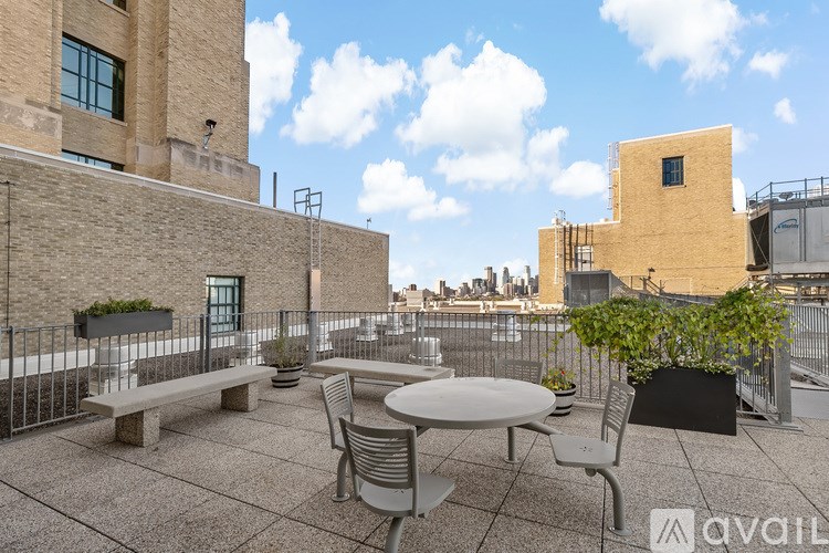 A patio with a table and chairs overlooking a cityscape.