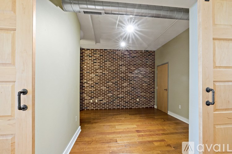 A room with a brick wall and wooden floors.