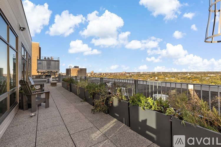 A rooftop patio with a bench and a planter box.
