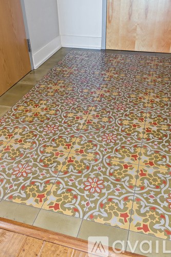 A tile floor with a floral pattern in the middle of it.