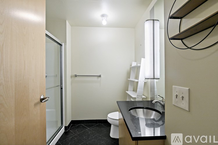 A bathroom with a sink, toilet, and mirror.
