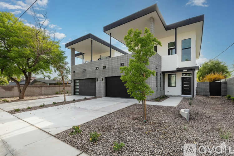A modern two-story house with a garage and a tree in front.
