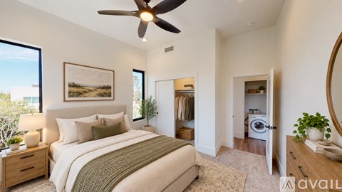A bedroom with a large bed and a ceiling fan.