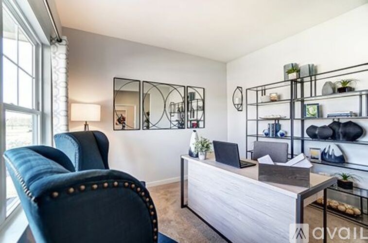 A blue chair sits in front of a desk with a laptop on it.