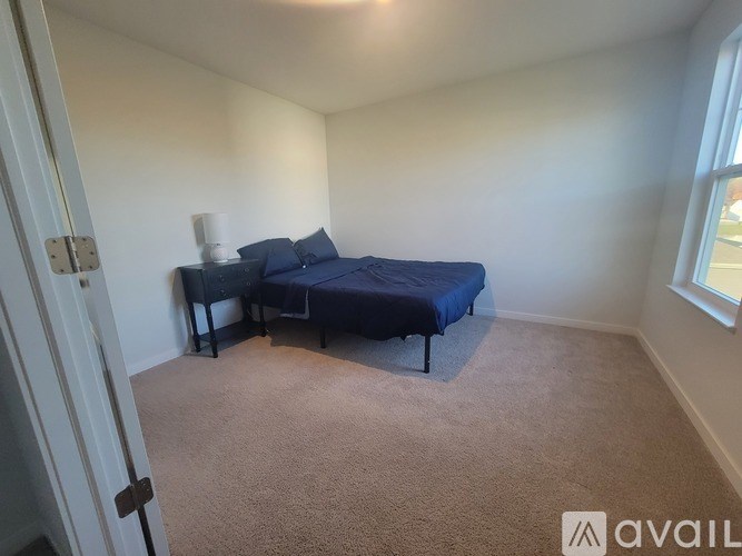 A room with a desk, chair, and a mirror on the wall.