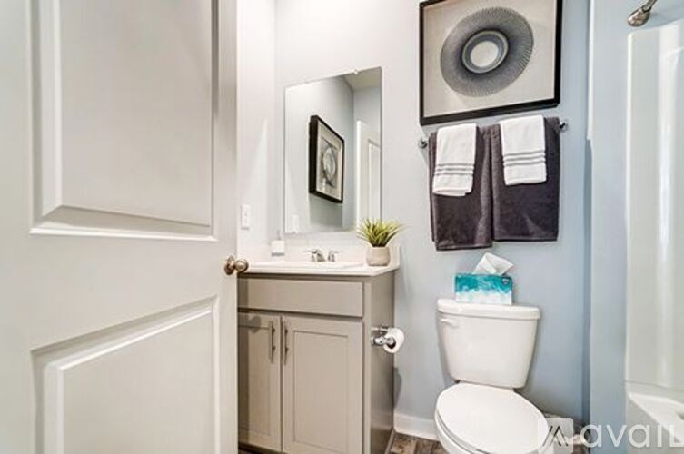 A white toilet sits in a bathroom next to a white sink.