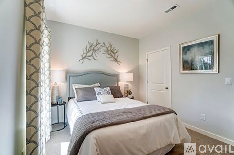 A bedroom with a large bed and a painting on the wall.