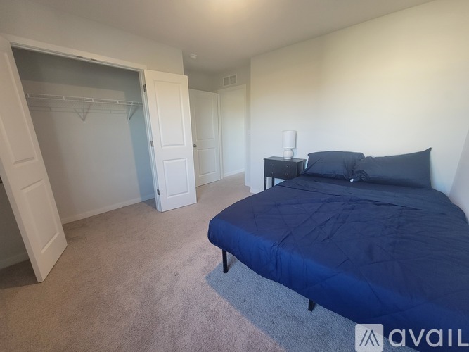 A living room with a white sofa and a TV on the wall.