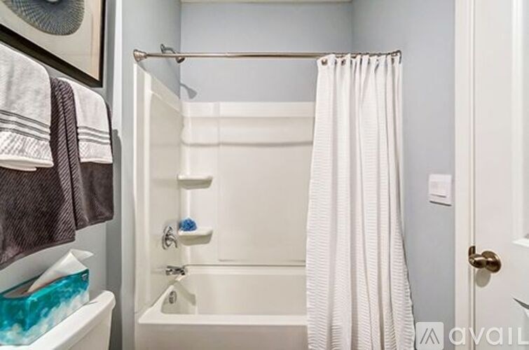 A white bathroom with a white tub and a white shower curtain.