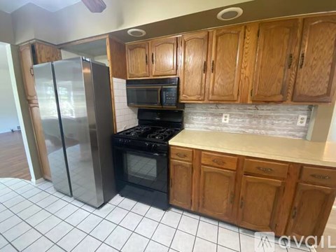A kitchen with wooden cabinets and a black stove top oven.