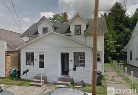 A white house with a black door and a small porch.