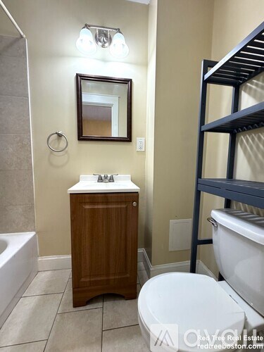 A small bathroom with a toilet, sink, and mirror.