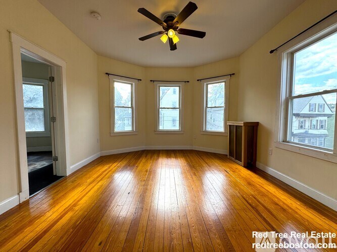 A room with wooden floors and a ceiling fan.