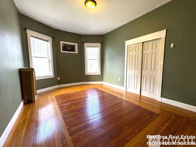 A room with wood flooring and a white door.