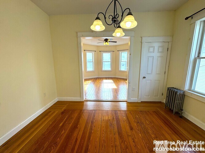 A room with wooden floors and a chandelier.