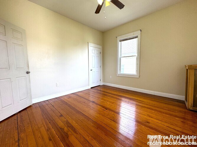 A room with wooden floors and a ceiling fan.